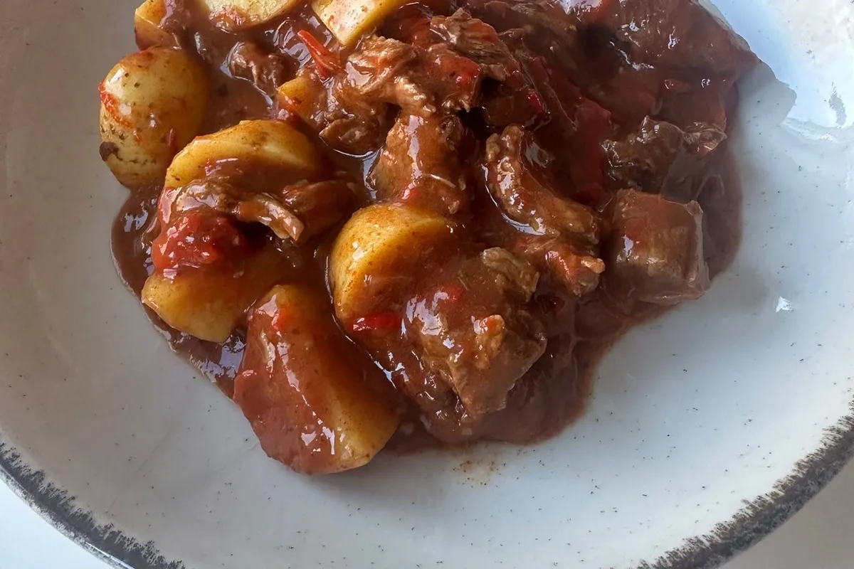 Gulasch med nötkött och potatis i en djup tallrik