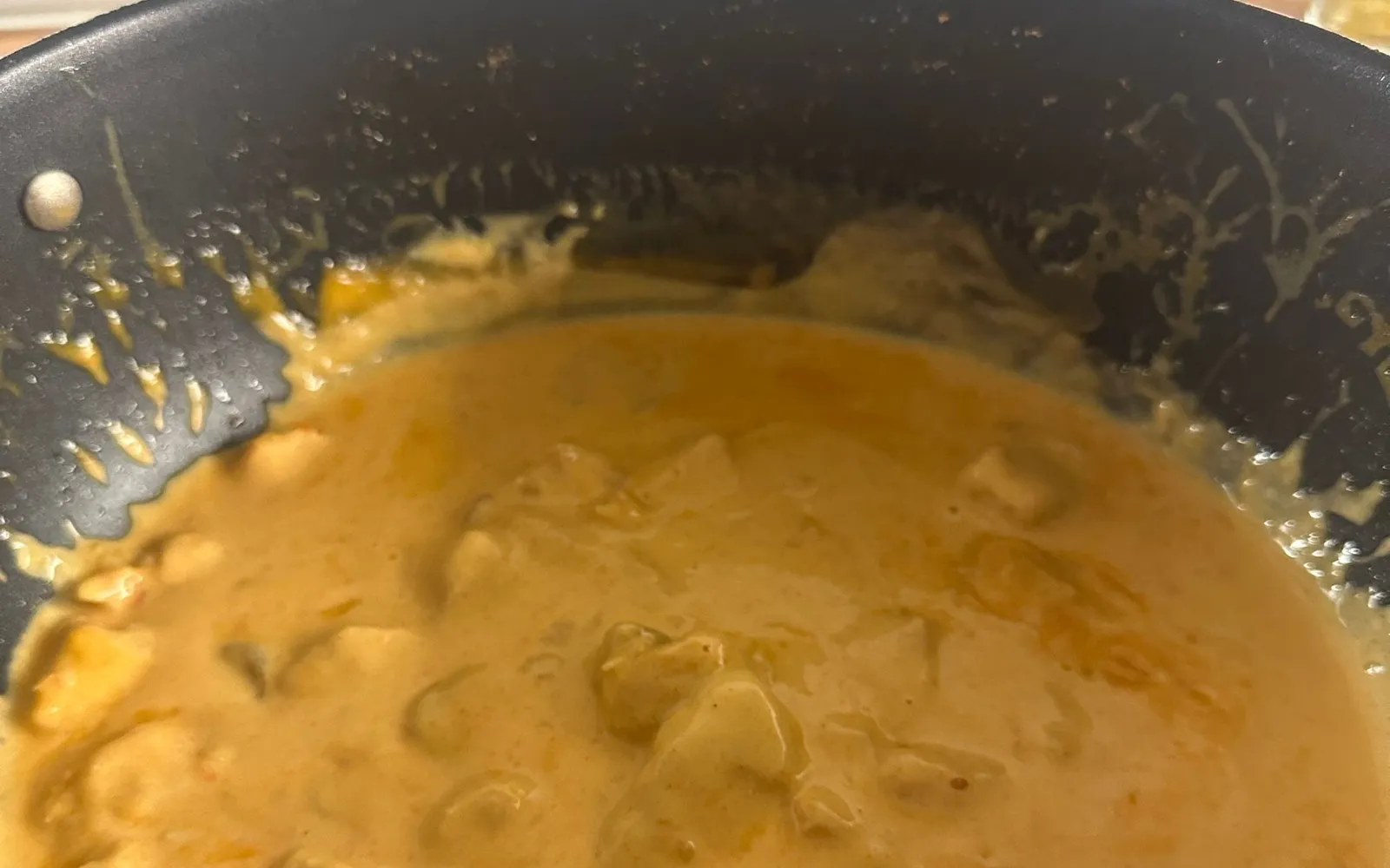 Kycklinggryta med mango chutney i en stekpanna på spisen