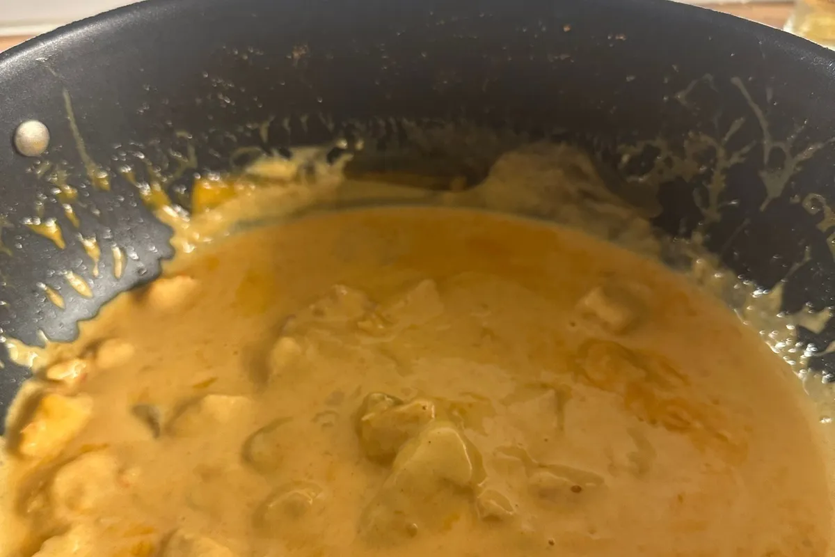 Kycklinggryta med mango chutney i en stekpanna på spisen